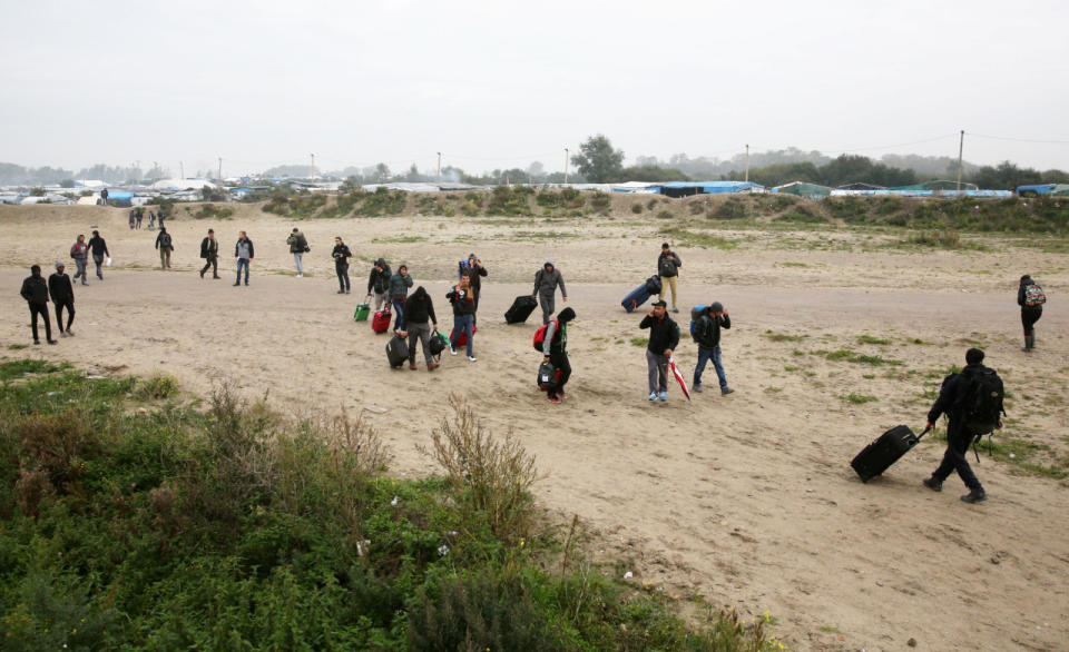 Migrants make their way out of the camp. 