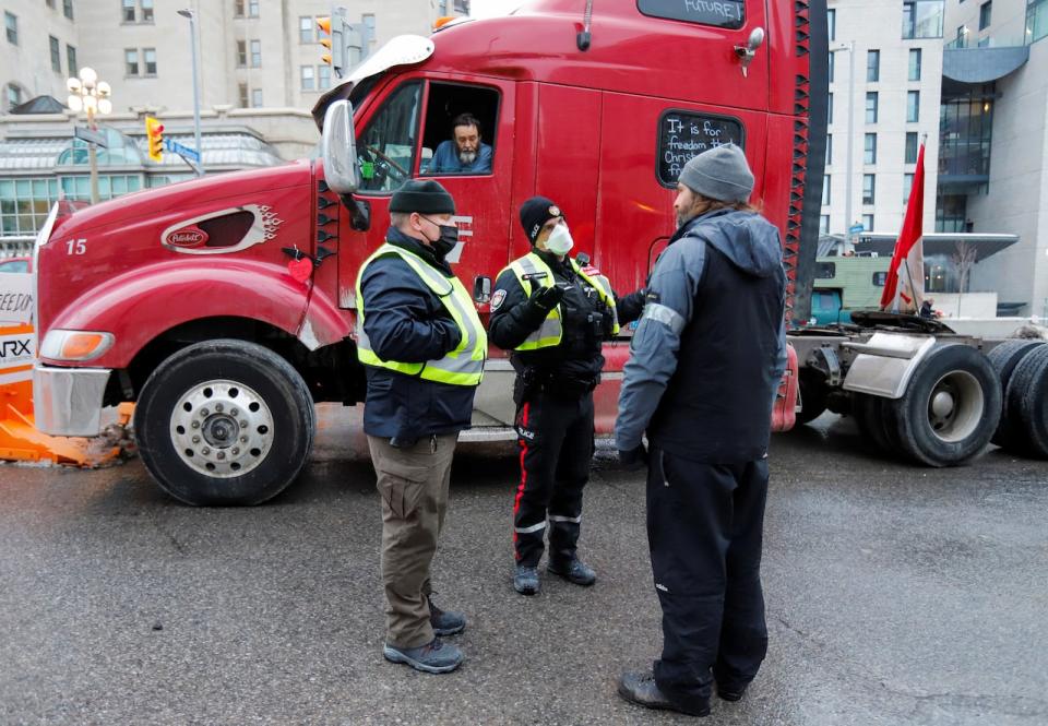 Police liaison officers speak to protesters during their ongoing demonstration in Ottawa, Feb. 10, 2022. 