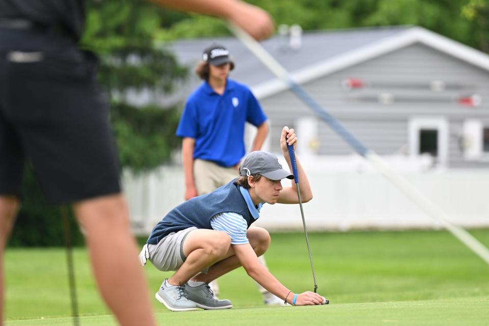 South Bend St. Joseph’s Thomas Raster places his ball to putt on the 5th hole Saturday, May 21, 2022, at Pretty Lake Golf Club in Plymouth.