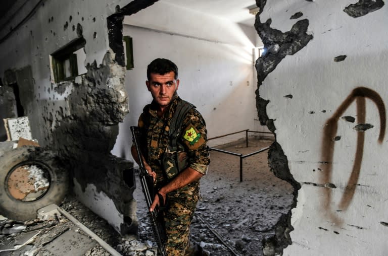 A member of the Syrian Democratic Forces inspects the municipal stadium in Raqa on October 18, 2017, after the US-backed forces retook the city from the Islamic State group