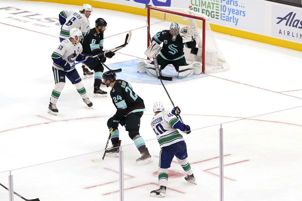 Seattle Kraken goalie Philipp Grubauer stops a shot from Vancouver Canucks' Elias Pettersson (40) during the second period of an NHL hockey game Saturday, Oct. 23, 2021, in Seattle. (AP Photo/Elaine Thompson)