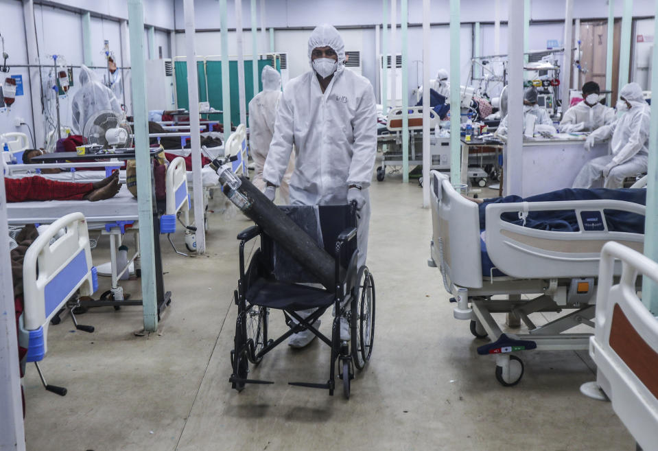A health worker brings an oxygen cylinder on a wheelchair at the BKC jumbo field hospital, one of the largest COVID-19 facilities in Mumbai, India, Thursday, May 6, 2021. (AP Photo/Rafiq Maqbool)