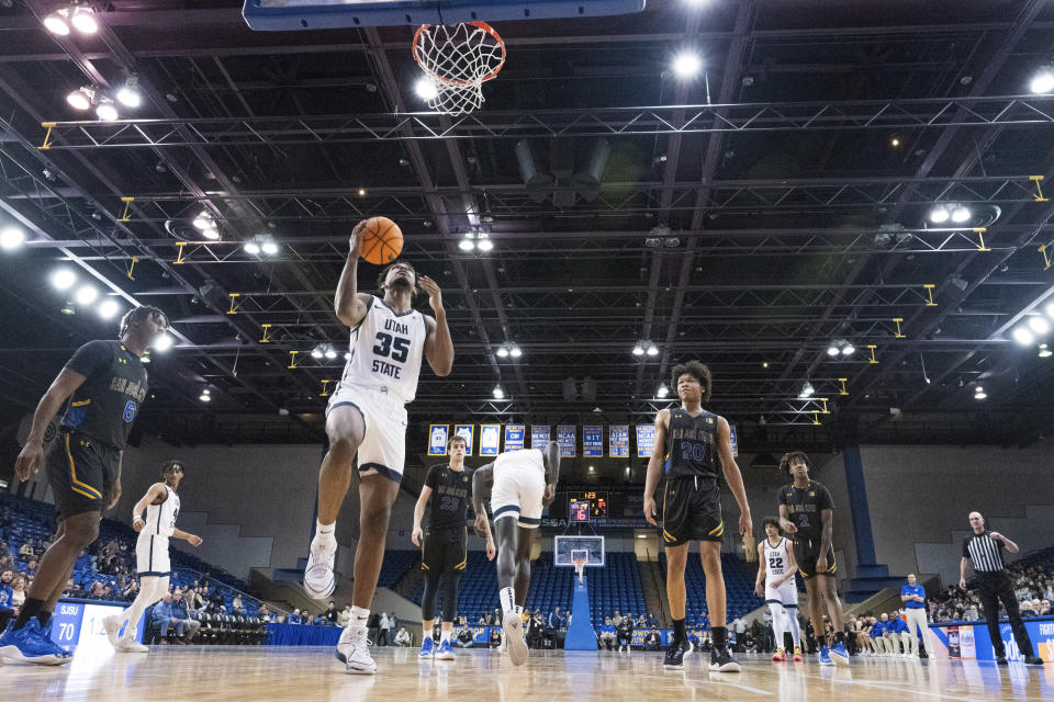 Utah State forward Nigel Burris (35) lays up a shot as San Jose State guard Latrell Davis (6) and forward Christian Wise (20) look on during the second half of an NCAA basketball game State Wednesday, March 6, 2024, in San Jose, Calif. (AP Photo/Nic Coury)