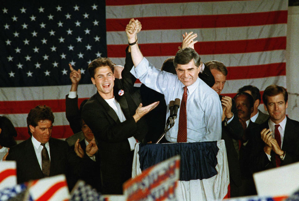 Democratic presidential candidate Michael Dukakis raises his hand in a victory salute with actor Rob Lowe for an enthusiastic crowd that greeted the Massachusetts governor at the Amtrack station in Stockton, Calif., on Sunday, Oct. 31, 1988, the last stop of his six-city whistle stop campaign through California?s central valley. (AP Photo/Rich Pedroncelli)