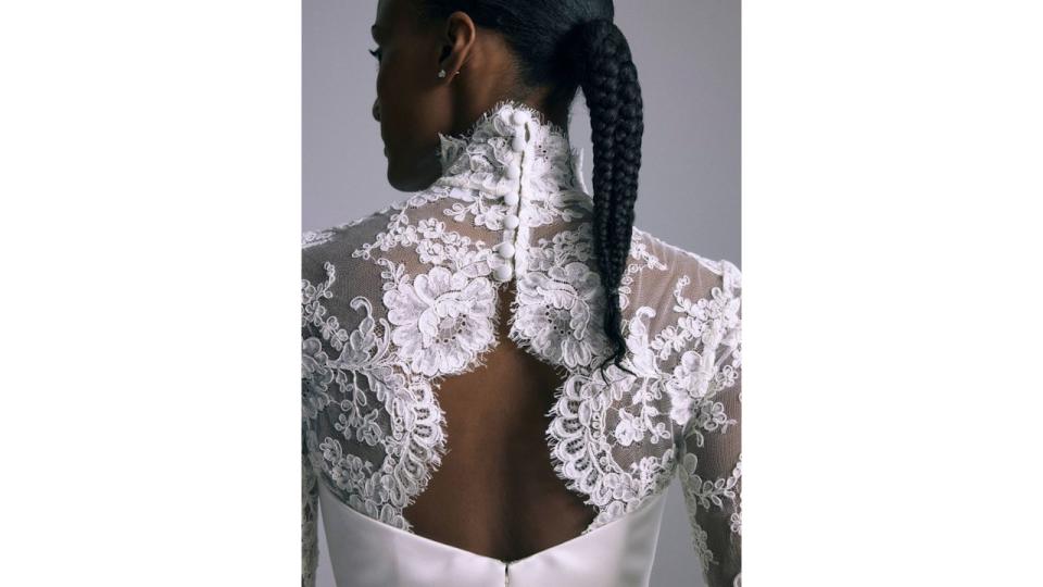 Model wears lace high neck wedding dress with a plait 