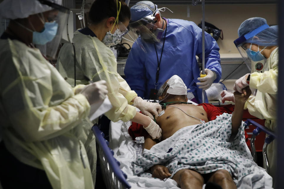 Dr. Anthony Leno, Director of Emergency Medicine, top center, assists nurses as they take in a patient from a nursing home showing symptoms of COVID-19, Monday, April 20, 2020, in Yonkers, N.Y. (AP Photo/John Minchillo)