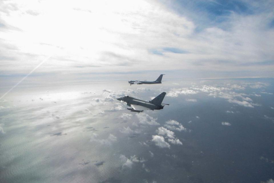 An RAF Eurofighter Typhoon (near) intercepting a Russian Bear F aircraft (far),: PA