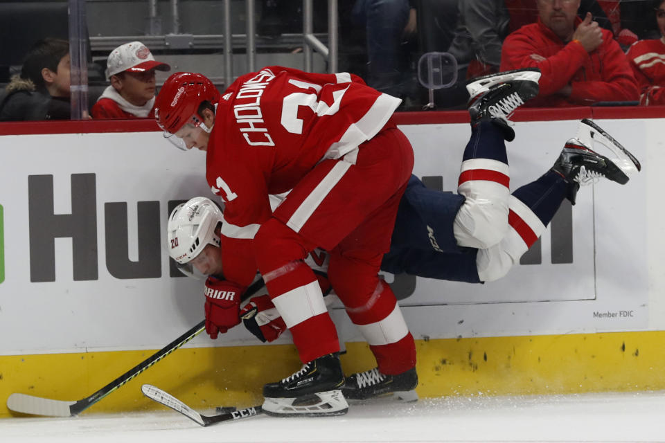 Detroit Red Wings defenseman Dennis Cholowski (21) checks Washington Capitals center Lars Eller (20) during the first period of an NHL hockey game Saturday, Nov. 30, 2019, in Detroit. (AP Photo/Carlos Osorio)