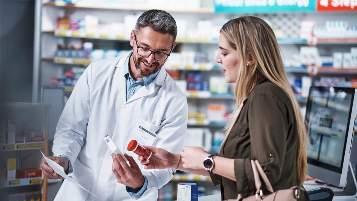 Shot of a mature pharmacist assisting a young woman in a chemist.