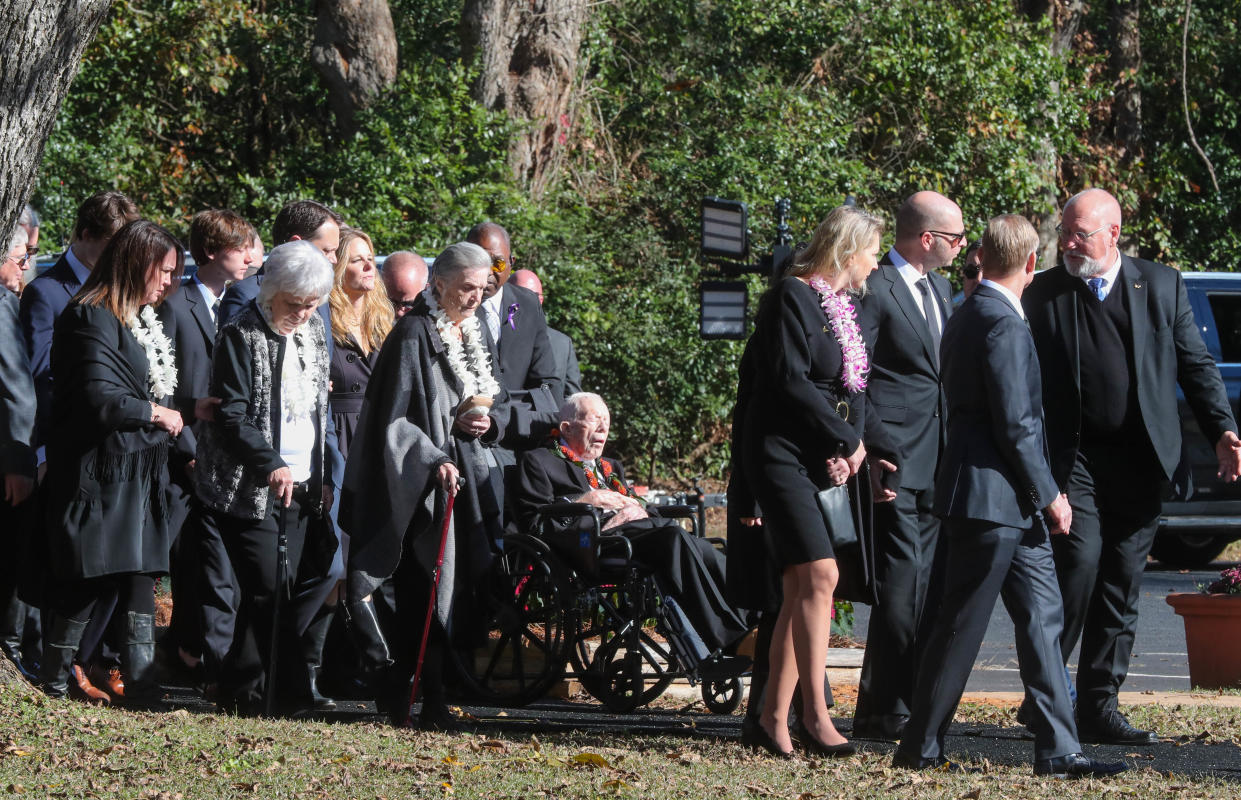 Nov 29, 2023; Plains, GA, USA; Family members surround former President Jimmy Carter as they walk to the entrance of Maranatha Baptist Church for the funeral service for former first lady Rosalynn Carter. Rosalynn Carter died Sunday, Nov. 19, 2023 at her home in Plains, Ga. at the age of 96.. Mandatory Credit: Richard Burkhart-USA TODAY