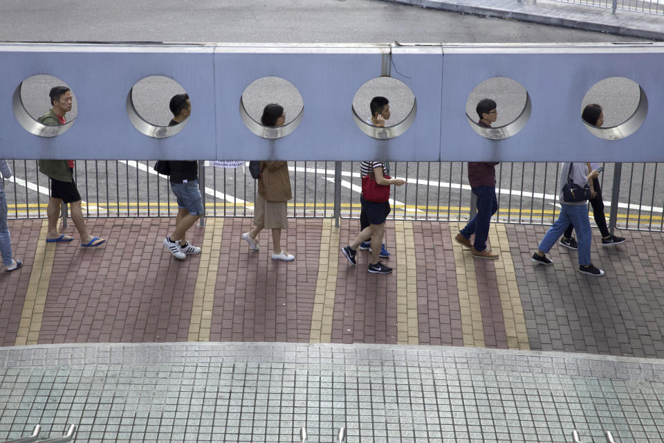 People line up to vote outside of a polling place in Hong Kong, Sunday, Nov. 24, 2019. Long lines formed outside Hong Kong polling stations Sunday in elections that have become a barometer of public support for anti-government protests now in their sixth month. (AP Photo/Ng Han Guan)