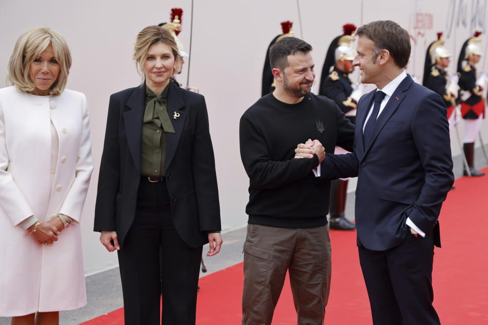 Ukrainian President Volodymyr Zelenskyy and his wife Olena Zelenska, arrive with French President Emmanuel Macron, right, and his wife Brigitte Macron, left, at the international ceremony at Omaha Beach, near Saint-Laurent-sur-Mer. Thursday, June 6, 2024. (Ludovic Marin, Pool via AP)