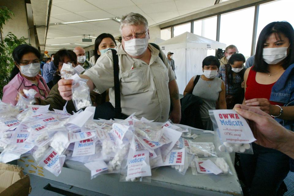 Arriving passengers help themselves to free vitamins, mostly Vitamin C or ascorbic acid, being provided by the Government at the Ninoy Aquino International Airport south of Manila Tuesday April 15, 2003 to help prevent them from catching the severe acute respiratory syndrome or SARS.