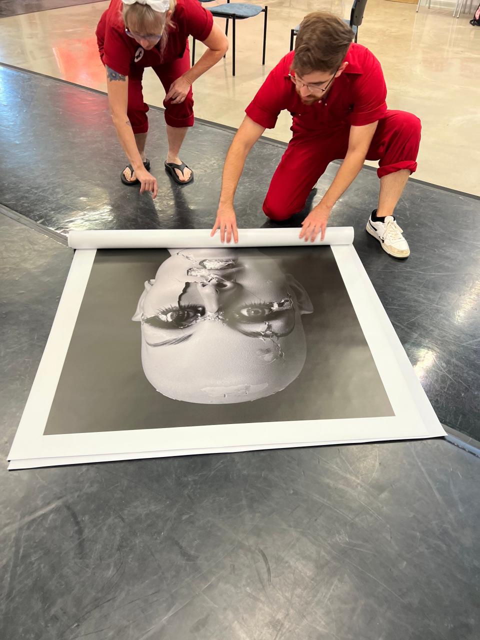 SPARK! Creative Lab artists Kiona Millirons, left, and Pedro Perez unroll the photo “Smashed” by Edmond photographer Neil Chapman in preparation for the artist collective's upcoming project "Ditty Bops: The Art of Listening." The project tells Chapman's life story, including his military service in the Vietnam War and his diagnosis with Parkinson’s disease due to his wartime exposure to Agent Orange.