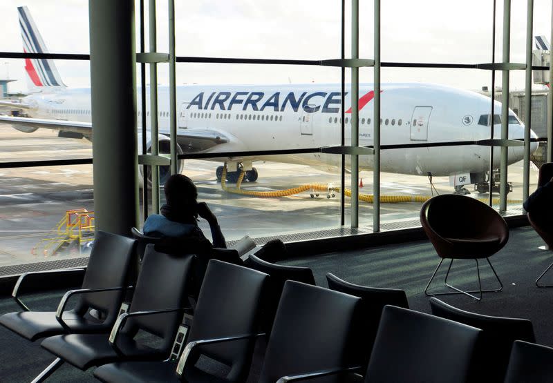 FILE PHOTO: A passenger waits for an Air-France flight inside the Terminal 2 at Paris Charles de Gaulle airport in Roissy-en-France near Paris