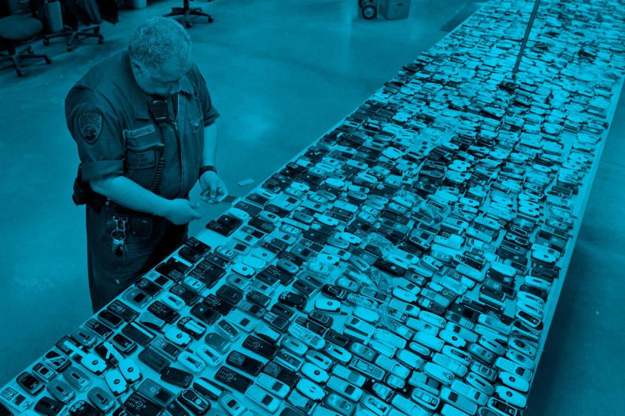 thousands of confiscated cell phones laid out on tables