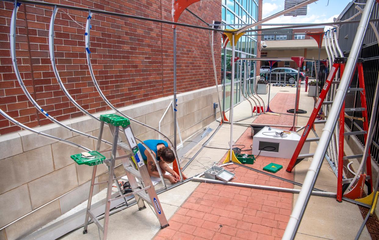 Esteban Garcia Bravo assembles a new art light installation in an alley near Third Street between Walnut Street and College Avenue on Wednesday, July 10, 2024