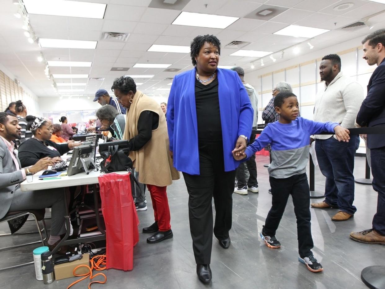 Stacey Abrams walks to a voting machine with her nephew in Decatur, Georgia: EPA