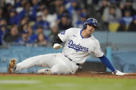 Los Angeles Dodgers' Shohei Ohtani scores on a ground ball by Freddie Freeman during the sixth inning of a baseball game against the Washington Nationals, Monday, April 15, 2024, in Los Angeles. (AP Photo/Marcio Jose Sanchez)