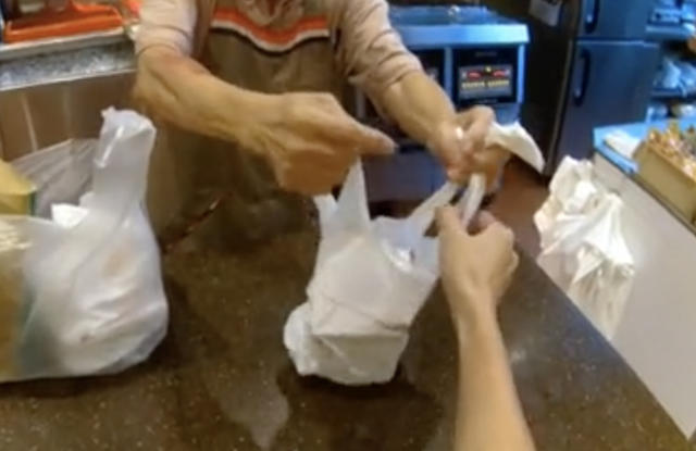 mos burger - elderly staff handing over order