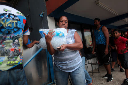 A woman buys ice at a local ice factory weeks after Hurricane Maria hit Puerto Rico in Orocovis, Puerto Rico, October 6, 2017. REUTERS/Alvin Baez