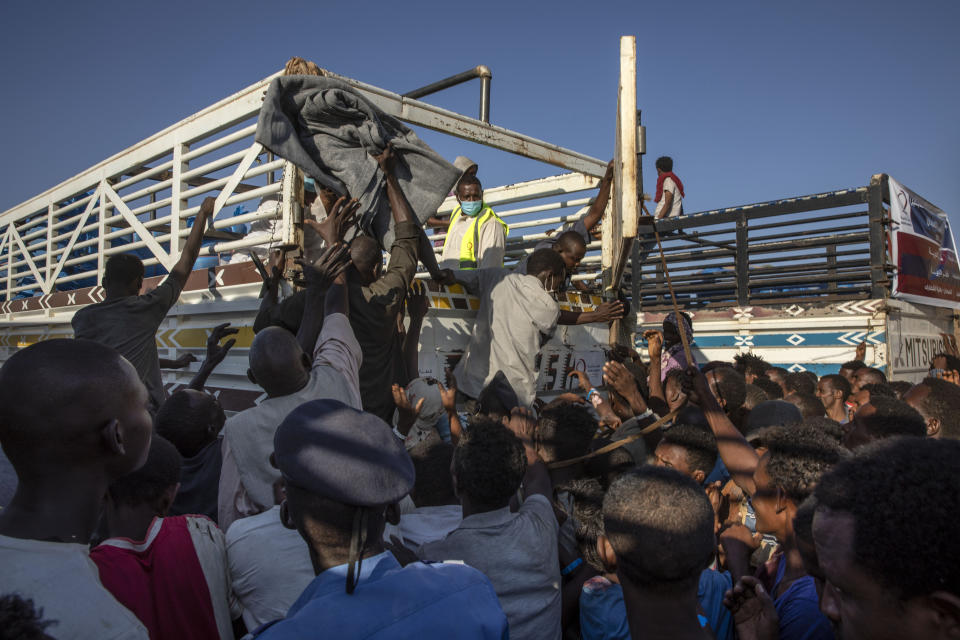 Tigray refugees who fled the conflict in Ethiopia's Tigray region, wait to receive aid at Umm Rakouba refugee camp in Qadarif, eastern Sudan, Tuesday, Nov. 24, 2020. (AP Photo/Nariman El-Mofty)