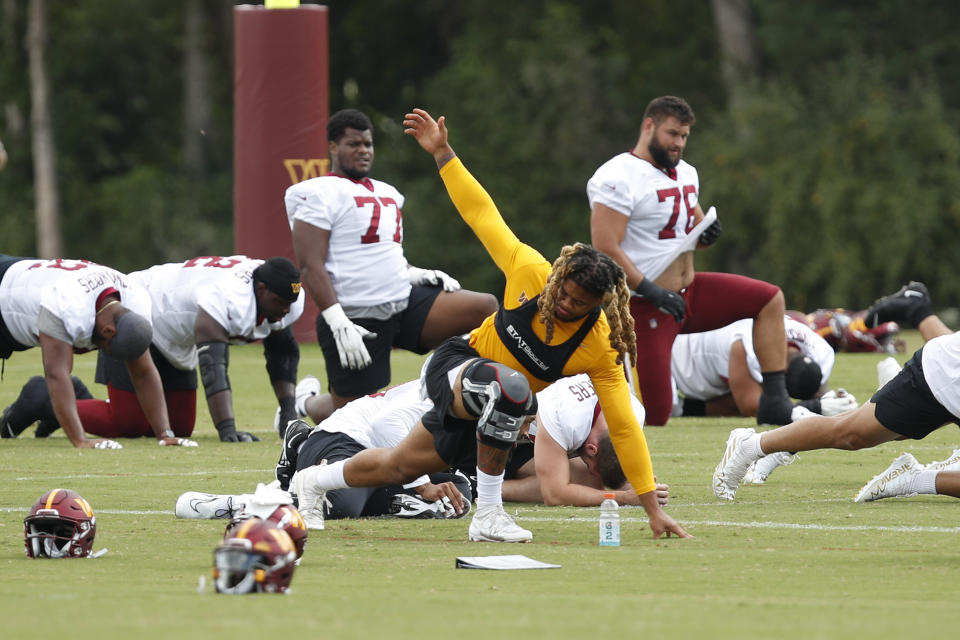 Washington Commanders defensive end Chase Young, center, warms up during an NFL football practice at Inova Sports Performance Center in Ashburn, Va., Monday, Aug. 22, 2022. (AP Photo/Luis M. Alvarez)