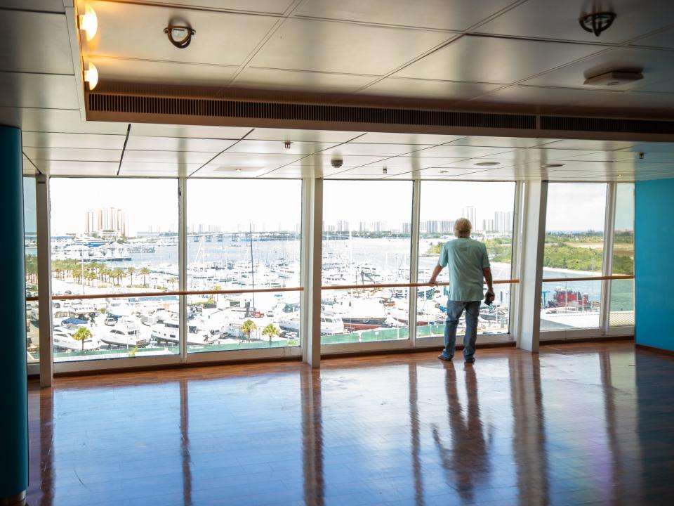 A person standing next to a large wall of windows.