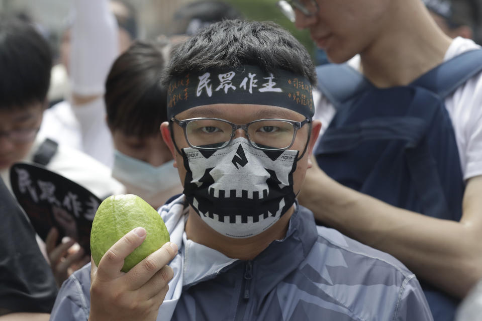 A supporter of opposition Taiwan People's Party (TPP) holds a guava, symbolizing dishonored ballot during a march to protest against Lai Ching-te's ruling Democratic Progressive party a day before his presidential inauguration in Taipei, Taiwan, Sunday, May 19, 2024. TPP demands that Lai''s government must implement parliamentary, judicial and constitutional reforms. (AP Photo/Chiang Ying-ying)