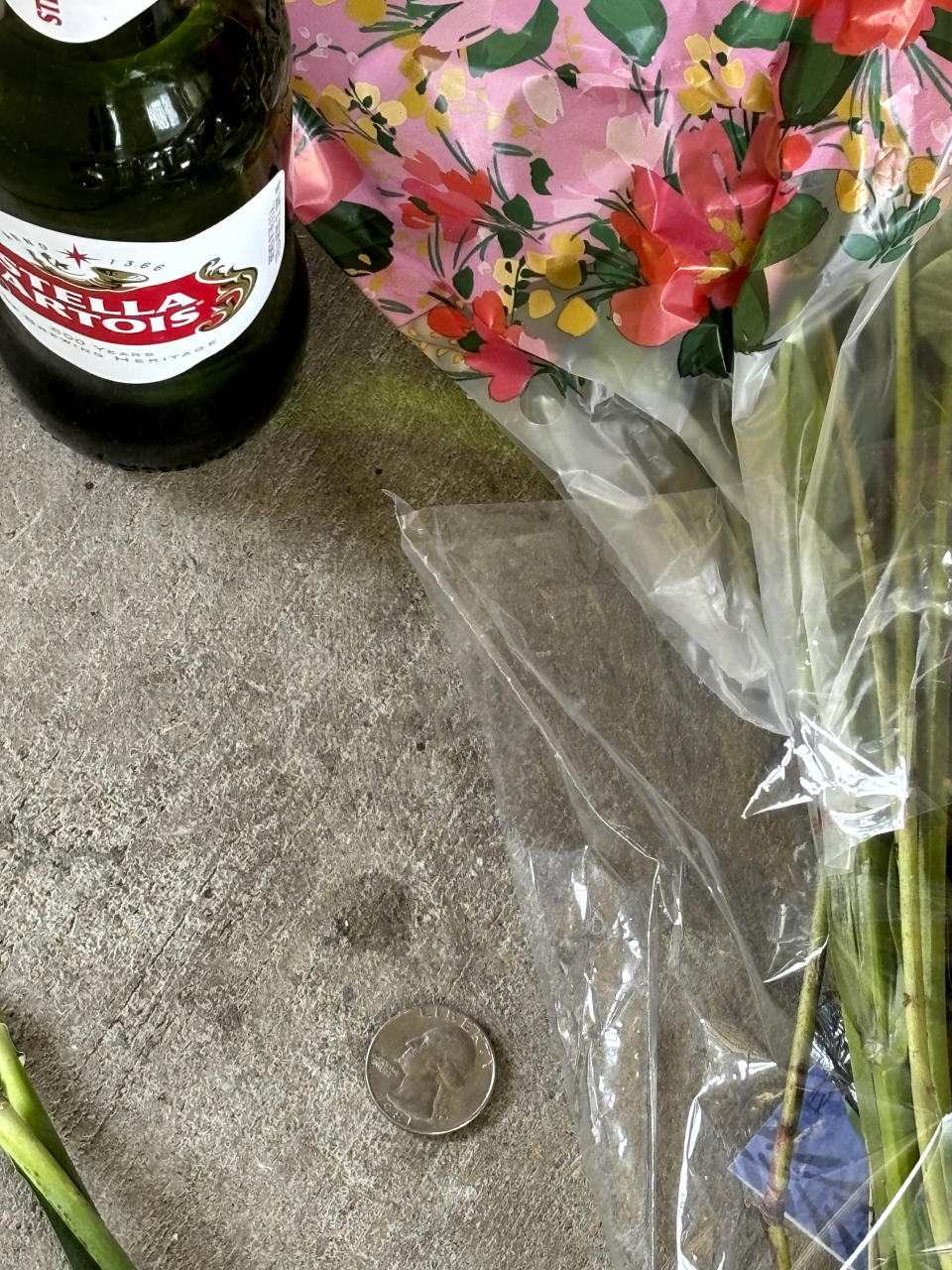 A small shrine is pictured Monday, May 13, 2024, in Fort Walton Beach, Fla. at the door of an apartment where a Florida deputy shot and killed Senior Airman Roger Fortson. The shrine includes a long wooden plank, anchored by two sets of aviator wings and a black marker to leave thoughts, a Stella Artois, and combat boots and an American Flag. As the unit takes a day to grieve and prepare for a funeral Friday, May 17, questions remain about the shooting. (AP Photo)