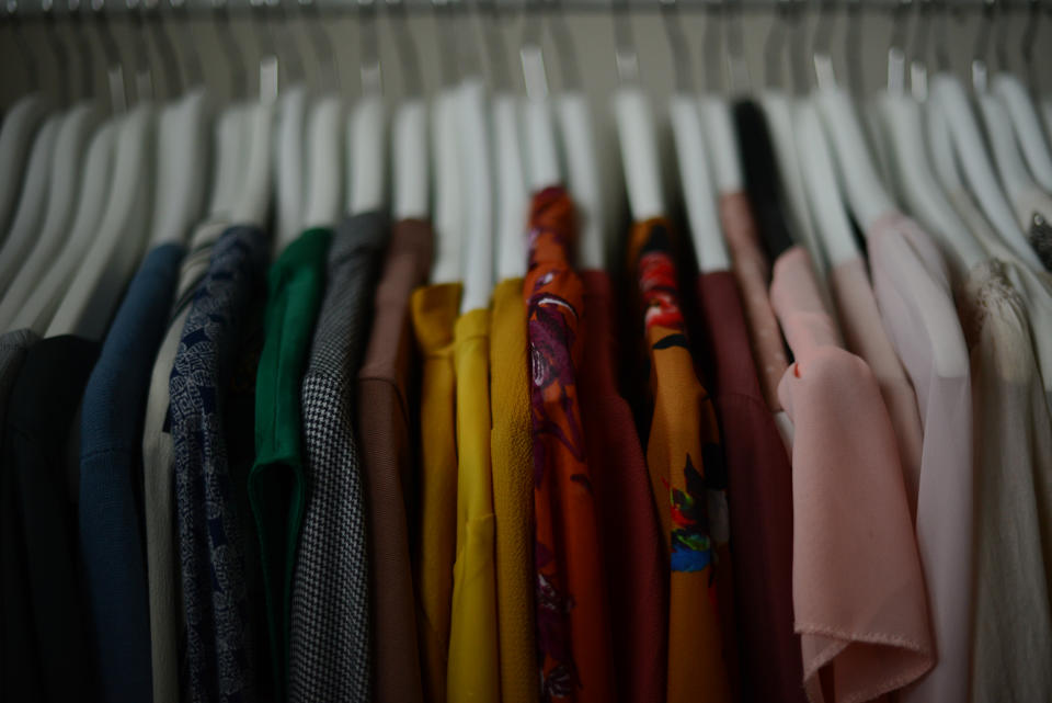 colorful blouses hanging on a white hangers in a row