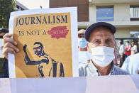 A supporters holds up a banner as he protests with others in front of the Casablanca Courthouse, in Casablanca, Morocco, Tuesday, Sept. 22, 2020, on the first day of the hearing of journalist and activist Omar Radi. The arrest of journalist Omar Radi follows numerous summons following a police investigation into suspicion of receiving funds linked to foreign intelligence. The investigation came after rights group Amnesty International accused Morocco of using Israeli-made spyware to snoop on its phone. (AP Photo/Abdeljalil Bounhar)