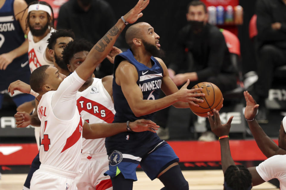 Minnesota Timberwolves' Jordan McLaughlin (6) drives past Toronto Raptors' Norman Powell during the first half of an NBA basketball game Sunday, Feb. 14, 2021, in Tampa, Fla. (AP Photo/Mike Carlson)