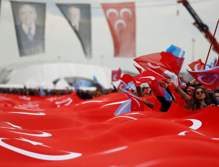 Supporters of Nationalist Movement Party (MHP) leader Devlet Bahceli carry a huge Turkish flag during a rally for the upcoming referendum, in Istanbul, Turkey. REUTERS/Osman Orsal