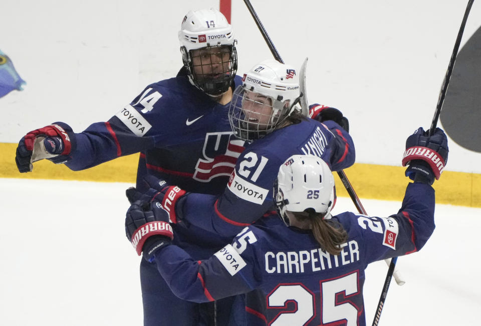 United States' Laila Edwards (14) celebrates after her goal over Finland with teammates Hilary Knight (21) and Alex Carpenter (25) during the second period in the semifinals of the IIHF women's world hockey championships Saturday, April 13, 2024, in Utica, N.Y. (Christinne Muschi/The Canadian Press via AP)