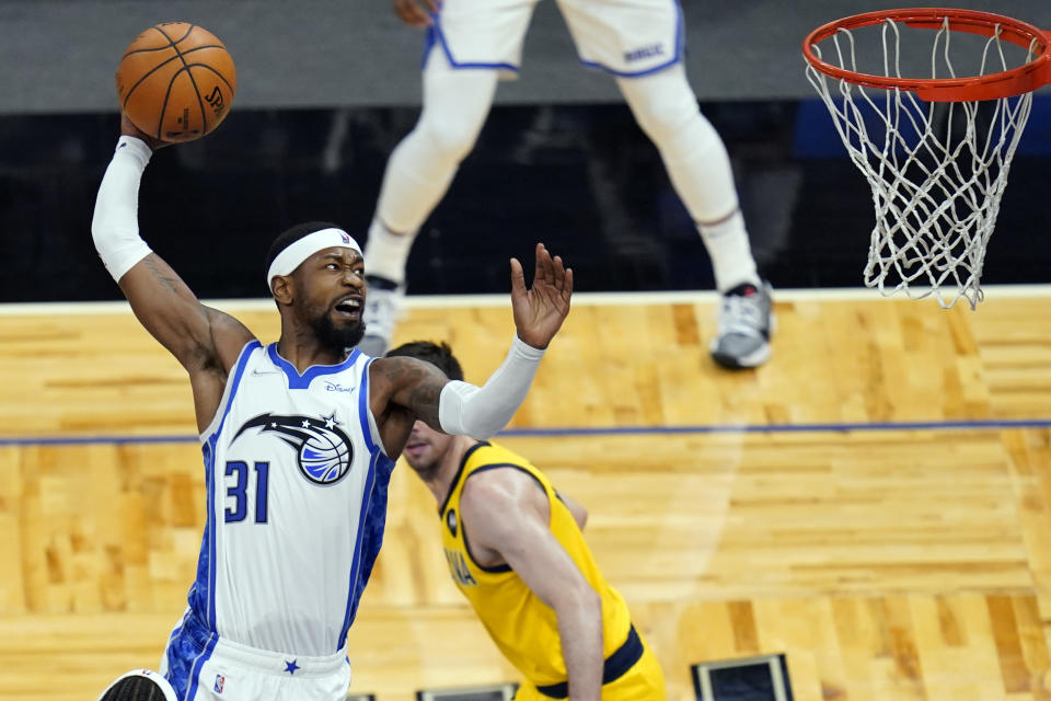 Orlando Magic guard Terrence Ross (31) goes up past Indiana Pacers guard T.J. McConnell, right, for a dunk during the second half of an NBA basketball game, Friday, April 9, 2021, in Orlando, Fla. (AP Photo/John Raoux)