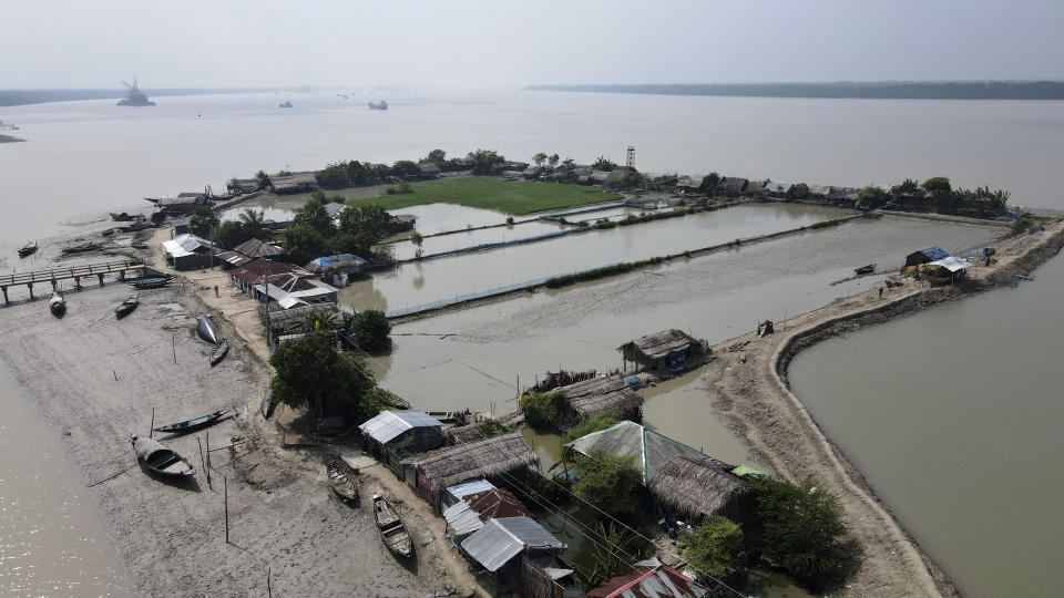 Boats sit near homes in the Sundarbans, the world’s largest mangrove forest, near the Maitree Super Thermal Power Project in Rampal, Bangladesh, Tuesday, Oct. 18, 2022. A power plant will start burning coal as part of Bangladesh’s plan to meet its energy needs and improve living standards, officials say. (AP Photo/Al-emrun Garjon)