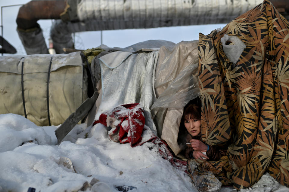 Una mujer sin hogar se asoma desde su refugio improvisado junto a unas tuberías calientes. (Foto: Alexey Malgavko / Reuters).