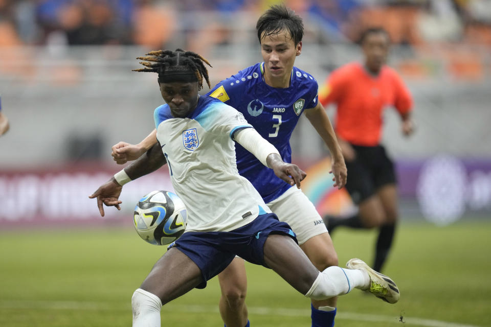 England's Joel Ndala, left, battles for the ball against Uzbekistan's Yakhyo Urinboev during their FIFA U-17 World Cup round of 16 soccer match at Jakarta International Stadium in Jakarta, Indonesia, Wednesday, Nov. 22, 2023. (AP Photo/Dita Alangkara)