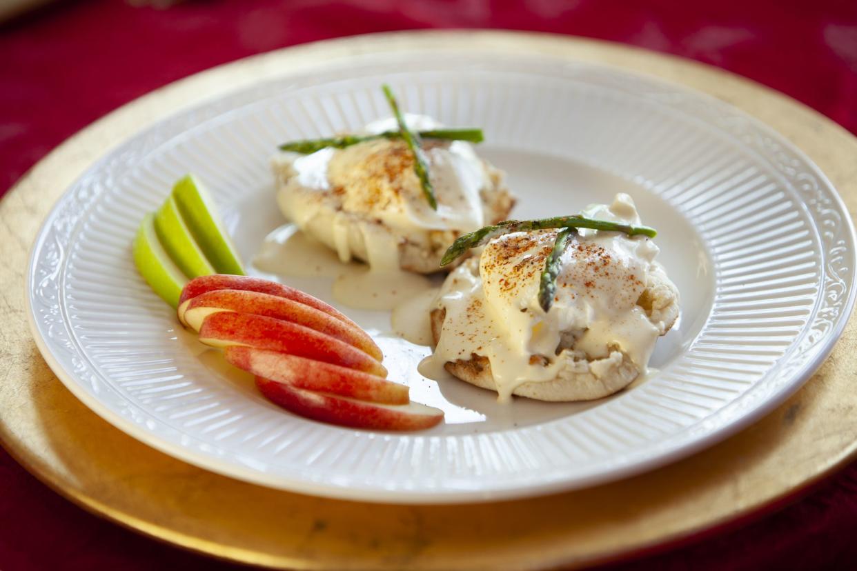 elegant serving of eggs Benedict for breakfast topped with tiny asparagus