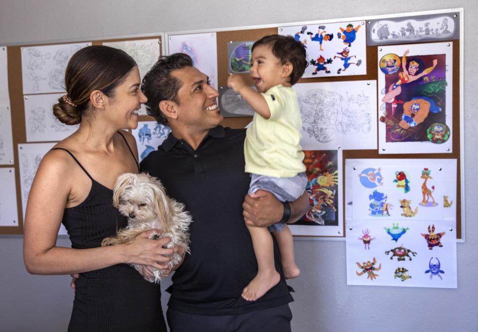 Artist Jose Zelaya, with his son Levi, 1, and wife Elle at their home in Burbank.