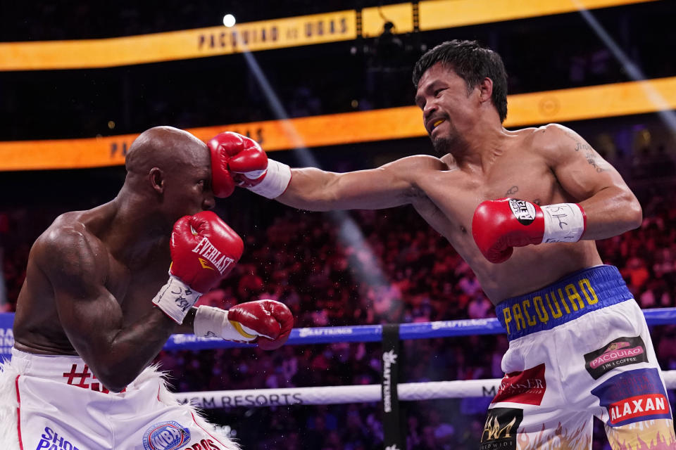 Manny Pacquiao, of the Philippines, hits Yordenis Ugas, of Cuba, in a welterweight championship boxing match Saturday, Aug. 21, 2021, in Las Vegas. (AP Photo/John Locher)