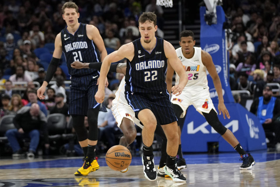 Orlando Magic's Franz Wagner (22) runs after a loose ball in front of center Moritz Wagner (21) and Miami Heat's Orlando Robinson (25) during the first half of an NBA basketball game, Saturday, Feb. 11, 2023, in Orlando, Fla. (AP Photo/John Raoux)