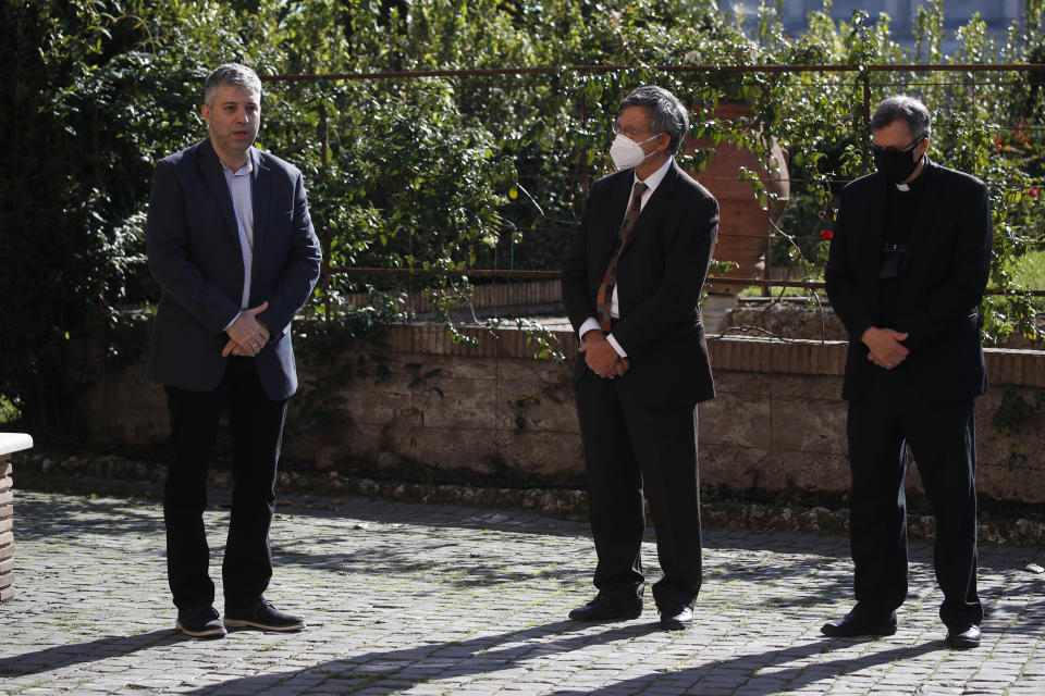 From left, director Evgeny Afineevsky, Paolo Ruffini, prefect of the dicastery of Communication, and Monsignor Ruiz, secretary of the dicastery, pose for a photo respecting the social distancing during the Kineo Movie for Humanity award ceremony at the Vatican, Thursday, Oct. 22, 2020. Director Evgeny Afineevsky was awarded with Kineo prize Thursday for the movie "Francesco". (AP Photo/Alessandra Tarantino)