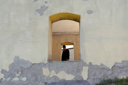 A rabbi stands in the window of a building at the Jewish cemetery in the village of Mad, Hungary, July 21, 2016. Picture taken July 21, 2016. REUTERS/Laszlo Balogh