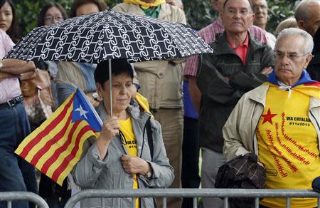 A woman holds an "Estelada" (Catalonia separatist flag) flag as she attends a ceremony to mark the "Diada de Catalunya" (Catalunya's National day) in central Barcelona September 11, 2013. REUTERS/Gustau Nacarino