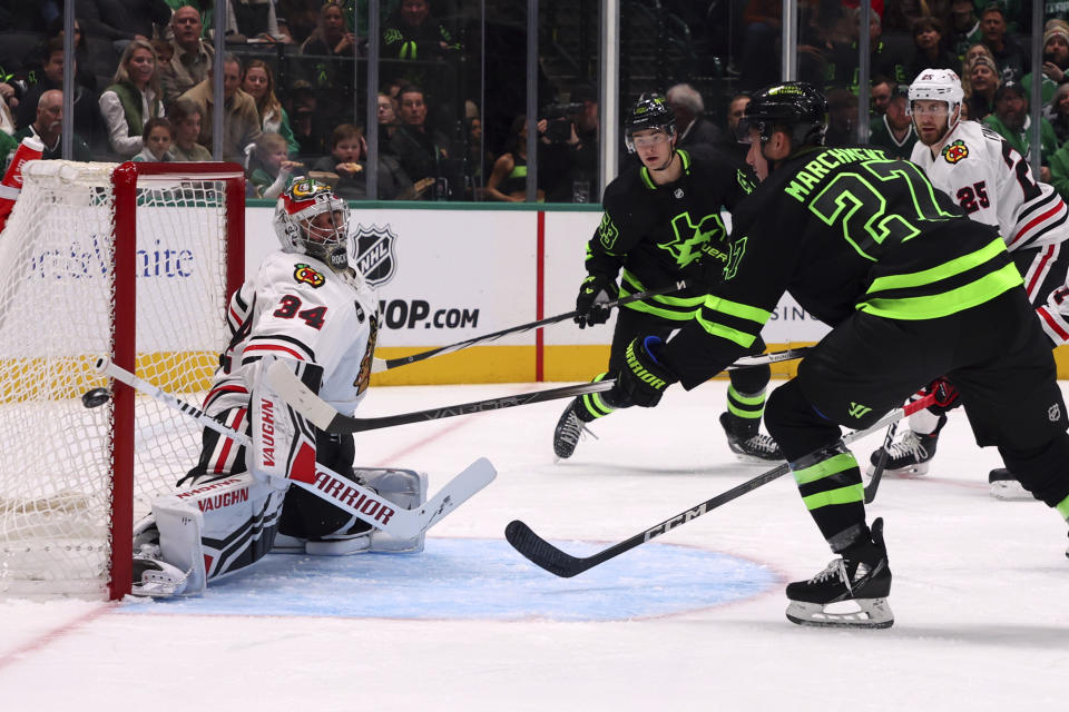 Dallas Stars left wing Mason Marchment (27) shoots against Chicago Blackhawks goaltender Petr Mrazek (34) in the first period of an NHL hockey game Sunday, Dec. 31, 2023, in Dallas. (AP Photo/Richard W. Rodriguez)