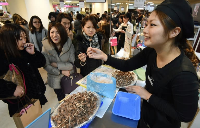 Women sample chocolates at the Printemps department store in Tokyo on February 9, 2016 ahead of Valentine's Day