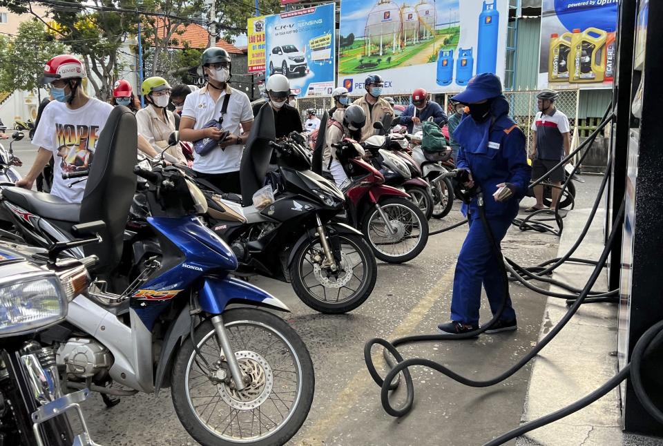 People wait for gas pump in Hanoi, Vietnam Sunday, June 19, 2022. Across the globe, drivers are rethinking their habits and personal finances amid skyrocketing prices for gasoline and diesel, fueled by Russia's war in Ukraine and the global rebound from the COVID-19 pandemic. Energy prices are a key driver of inflation that is rising worldwide and making the cost of living more expensive.(AP Photo/Hau Dinh)