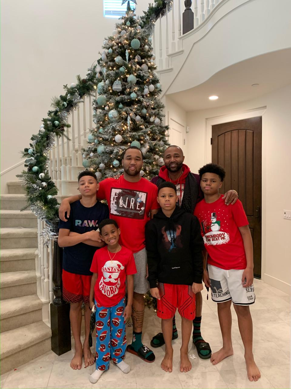 Mo Williams stands with his sons in front of a Christmas tree